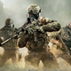 A group of five heavily armed soldiers stand together in a dusty environment.